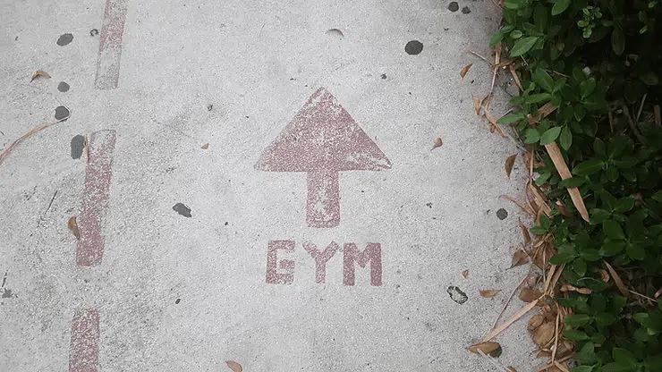 Gym direction arrow painted on concrete walkway outdoors